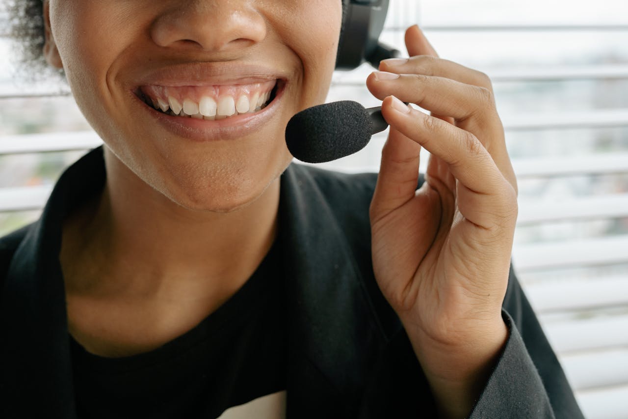 Home Close-up of a smiling call center representative holding a microphone.
