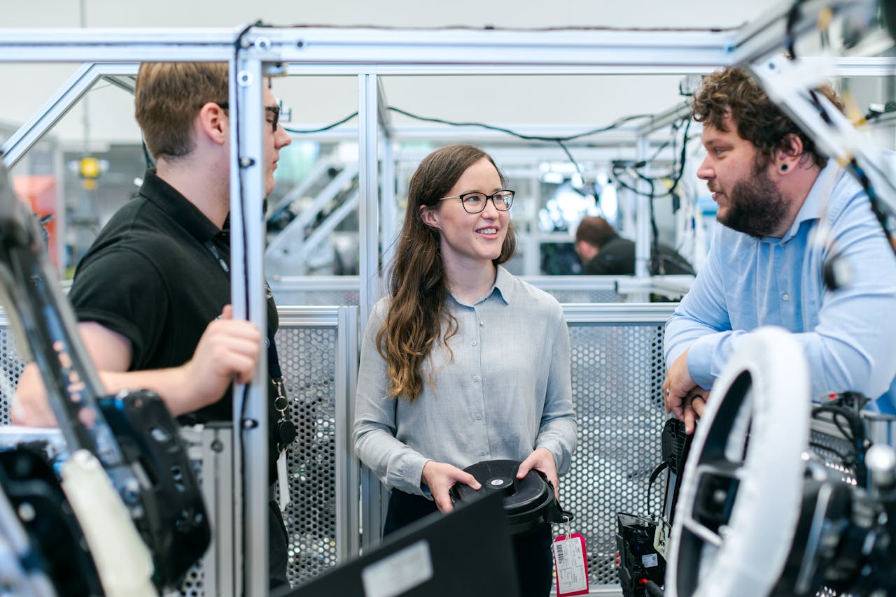 About Group of engineers collaborating on a project in a tech-focused industrial setting.