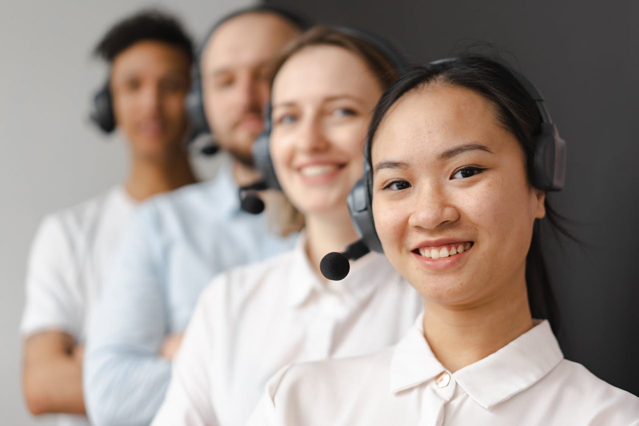 Home Smiling diverse team of customer support representatives wearing headsets, ready to assist.